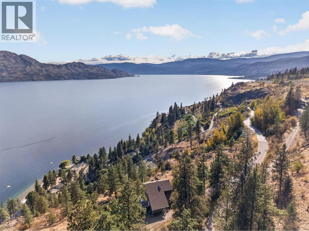 Perched above Okanagan Lake on 1.77 private acres, surrounded by nature and panoramic lake and mountain views