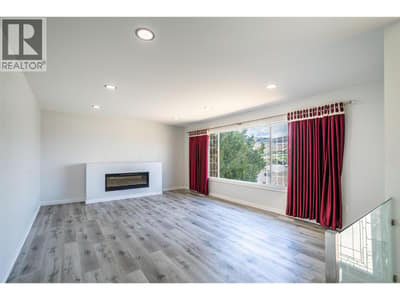 Living room with electric fireplace, laminate flooring, pot lights and large picture window