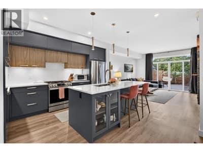 Modern kitchen with custom cabinetry, quartz countertops and a large centre island.