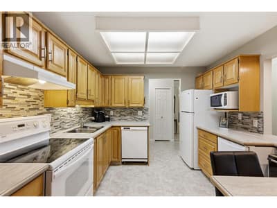 Functional kitchen with ample cabinetry, & white appliances