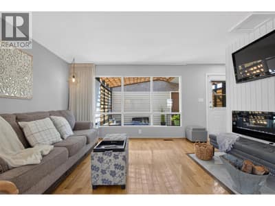 Bright and inviting living room with large windows, plenty of natural light, and a comfortable layout perfect for relaxing or spending time with family.