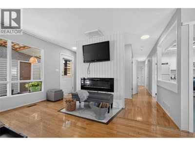 Bright and inviting living room featuring an electric fireplace and direct access to the outdoor patio, creating an easy flow between indoor and outdoor living.