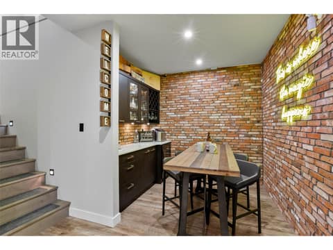 As we come into the lower level - gorgeous old 65 year old brick designing this bar area at 229 Holloway Drive, Tobiano, Kamloops