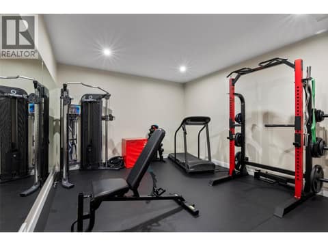 Fabulous workout room with rubber mat flooring and mounted mirrors at 229 Holloway Drive, Tobiano, Kamloops
