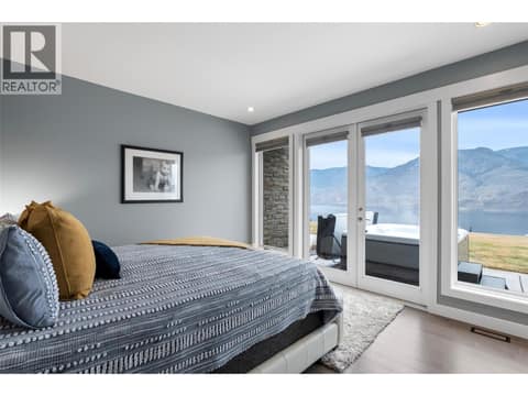Primary bedroom with its own doors to the back exterior at 229 Holloway Drive, Tobiano, Kamloops