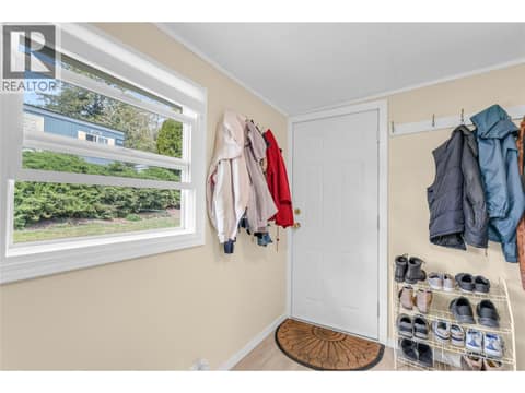 Den or mud room with a door to access the back yard and workshop. at 12022 Pretty Road Unit# 16, Lake Country South West