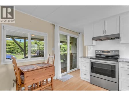 View of kitchen with the entry door and deck in the background. Eating nook with a great view of the yard. at 12022 Pretty Road Unit# 16, Lake Country South West