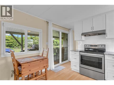 View of kitchen with the entry door and deck in the background. Eating nook with a great view of the yard. at 12022 Pretty Road Unit# 16, Lake Country South West