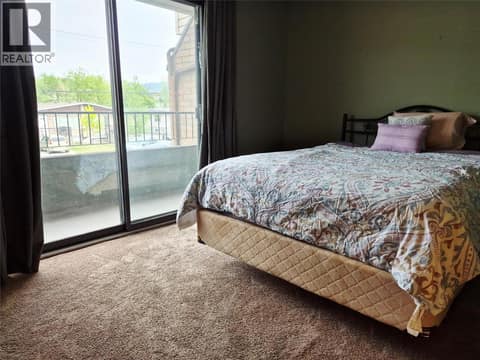Primary bedroom with sliding doors to a deck at 4102 24 Avenue Unit# 2, South Vernon