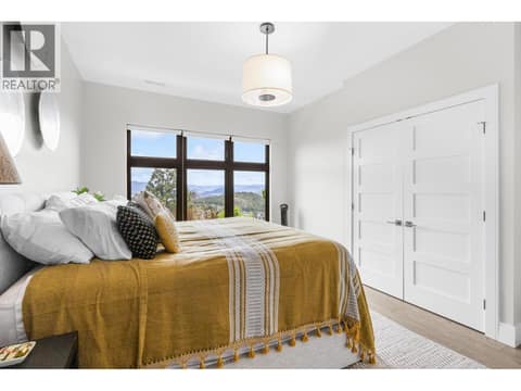 Bright and airy basement bedroom with large picture windows framing beautiful Wilden valley and mountain views, offering ultimate comfort and privacy for guests or family. at 162 Skyland Drive, Wilden, Kelowna