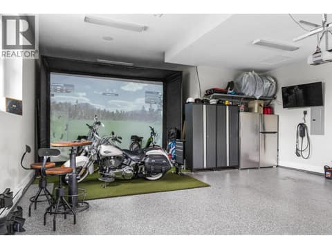 Oversized 3-car garage with EV charging capability, currently hosting a premium golf simulator room for year-round recreation. at 162 Skyland Drive, Wilden, Kelowna