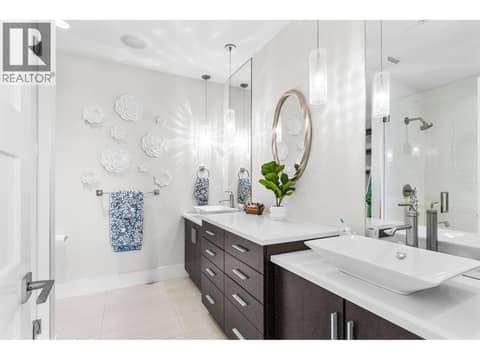 Private lower-level ensuite bathroom featuring a modern vanity, a combination tub and shower tile-surround, and premium fixtures tailored for a secondary bedroom suite. at 162 Skyland Drive, Wilden, Kelowna