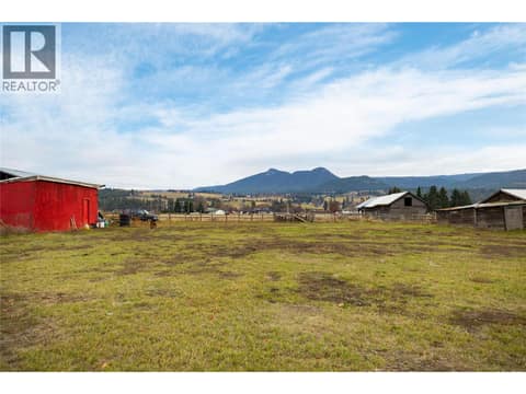 Large flat yard view from back door out of garage at 5712 6 Highway, Lavington, Vernon