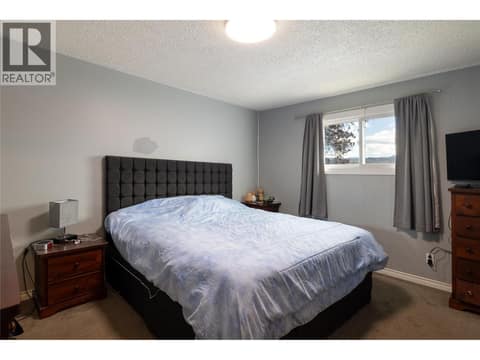 Main floor primary bedroom at 5712 6 Highway, Lavington, Vernon