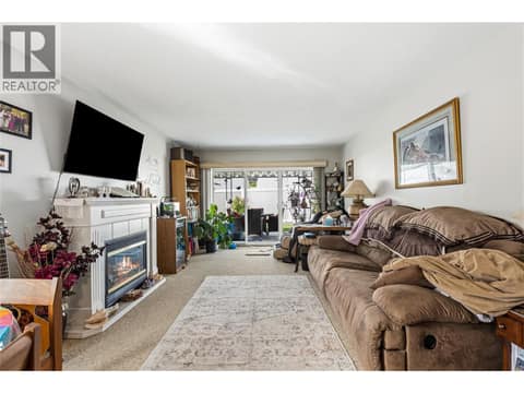 Warm and inviting living room complete with a cozy fireplace, perfect for relaxing evenings at home. at 3900 27 Avenue Unit# 49, Westmount, Vernon