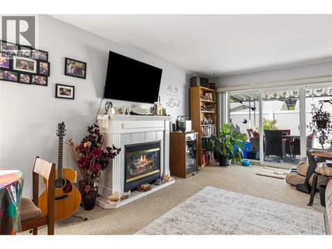 Warm and inviting living room complete with a cozy fireplace, perfect for relaxing evenings at home. at 3900 27 Avenue Unit# 49, Westmount, Vernon
