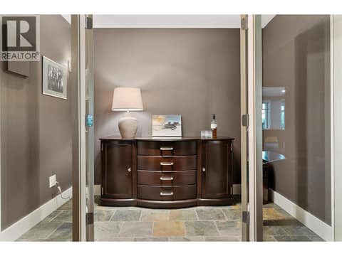 Glass door enclosures leading to a wine room at 108 Mashie Crescent, Predator Ridge, Vernon