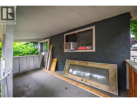 Shady back deck with a new door and window waiting Buyer to install for direct deck access from house at 5008 Heritage Drive, Westmount, Vernon