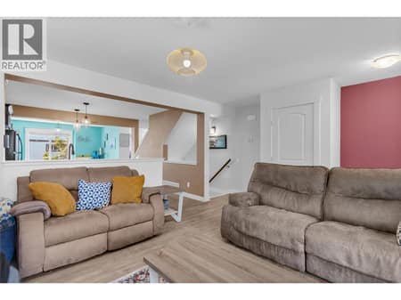 Stairs from the front entry/lobby in the background. Living room and kitchen area. at 1651 Lynrick Road Unit# 128, Black Mountain, Kelowna