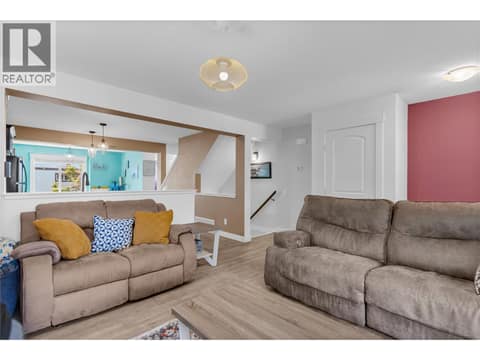 Stairs from the front entry/lobby in the background. Living room and kitchen area. at 1651 Lynrick Road Unit# 128, Black Mountain, Kelowna