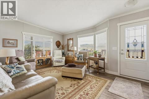 Beautiful living room with lots of natural light and front door on right at 12560 Westside Road Unit# 51, Swan Lake West, Vernon