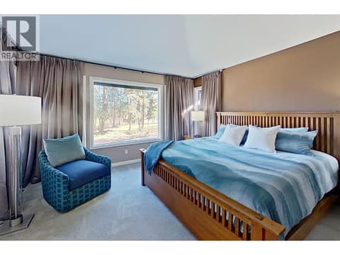 Primary bedroom with private view window at 3907 Gallaghers Circle, South East Kelowna