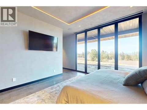 Lower level primary bedroom with glass doors to outdoor access at 4275 Todd Road, South East Kelowna