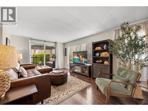 A bright and inviting living room offers the perfect place to gather, with large windows and seamless access to the private outdoor deck. at 4075 McClain Road Unit# 22, South East Kelowna