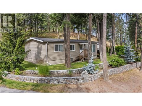 Exceptional curb appeal enhanced by timeless stone retaining walls and lush landscaping. at 4075 McClain Road Unit# 22, South East Kelowna