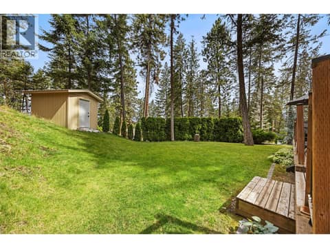 The detached workshop/shed, expansive lawn, and natural hillside combine to create a backyard that's as functional as it is beautiful. at 4075 McClain Road Unit# 22, South East Kelowna