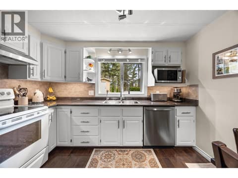 This thoughtfully updated kitchen offers abundant cabinetry, generous counter space, and a large window overlooking the peaceful, treed surroundings. at 4075 McClain Road Unit# 22, South East Kelowna
