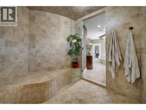 Natural stone finishes bring a spa quality feel to this bathroom at 336 Quilchena Drive, Kettle Valley, Kelowna
