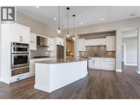 Living area flows into chefs kitchen at 3303 Water Birch Circle, McKinley Landing, Kelowna