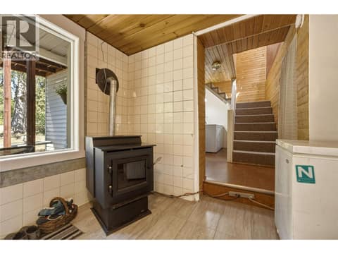 Laundry area and stairs to upper level at 244 Mabel Lake Road, Lumby Valley