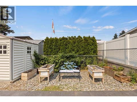 A dedicated garden area with raised planters, mature greenery and additional storage nearby. at 9020 Jim Bailey Road Unit# 151, Lake Country East / Oyama, Kelowna