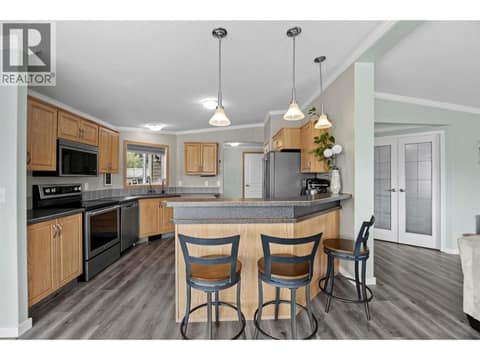 Generous peninsula with bar seating adds casual dining, extra prep space and storage while keeping the kitchen connected to the rest of the home. at 9020 Jim Bailey Road Unit# 151, Lake Country East / Oyama, Kelowna