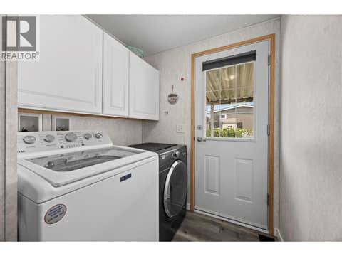 Separate laundry room with full-size washer and dryer, additional upper cabinetry for storage and direct access to the covered outdoor area. at 9020 Jim Bailey Road Unit# 151, Lake Country East / Oyama, Kelowna