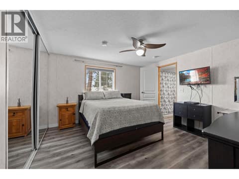 Spacious primary bedroom with updated flooring, a large mirrored closet and plenty of room for a king-size bed and additional furniture. at 9020 Jim Bailey Road Unit# 151, Lake Country East / Oyama, Kelowna