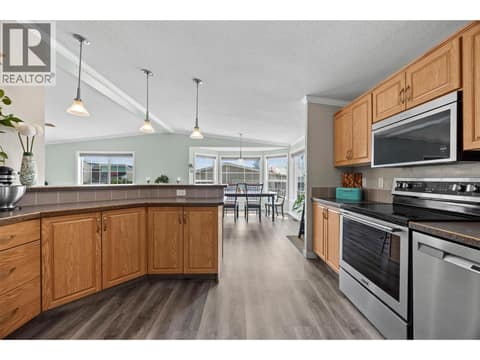 The kitchen opens beautifully into the bright dining area, creating an easy flow for entertaining while the expansive peninsula provides even more counter and storage space. at 9020 Jim Bailey Road Unit# 151, Lake Country East / Oyama, Kelowna