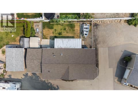 Top-down aerial showcases the home's footprint, attached garage, covered deck, yard, storage shed and outdoor space. at 9020 Jim Bailey Road Unit# 151, Lake Country East / Oyama, Kelowna