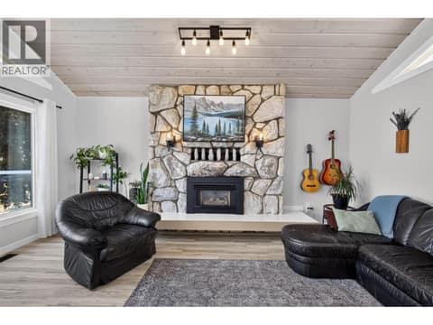 Stone fireplace anchors the space at 3491 Fenton Road, Glenrosa, West Kelowna