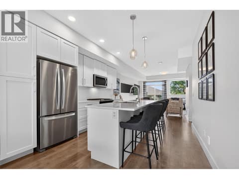 Beautiful kitchen featuring quartz countertops, a large island with bar seating, gas range, abundant cabinetry, and plenty of prep space for cooking and entertaining. at 720 Valley Road Unit# 28, North Glenmore, Kelowna