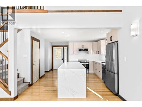 Kitchen | Main Level - Freshly renovated kitchen with quartz countertops, a waterfall island, and all new stainless steel appliances at 17936 Angus Road, Lake Country North West