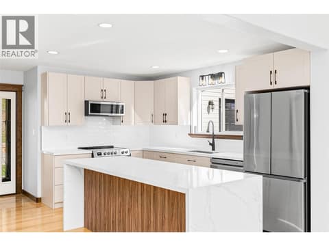 Kitchen | Main Level - Freshly renovated kitchen with quartz countertops, a waterfall island, and all new stainless steel appliances at 17936 Angus Road, Lake Country North West