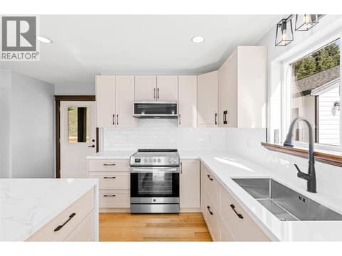 Kitchen | Main Level - Freshly renovated kitchen with quartz countertops, a waterfall island, and all new stainless steel appliances at 17936 Angus Road, Lake Country North West