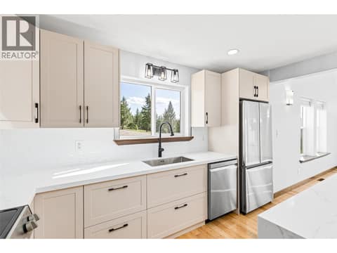 Kitchen | Main Level - Freshly renovated kitchen with quartz countertops, a waterfall island, and all new stainless steel appliances at 17936 Angus Road, Lake Country North West