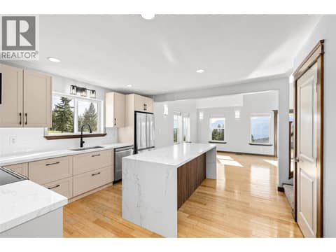 Kitchen | Main Level - Freshly renovated kitchen with quartz countertops, a waterfall island, and all new stainless steel appliances at 17936 Angus Road, Lake Country North West