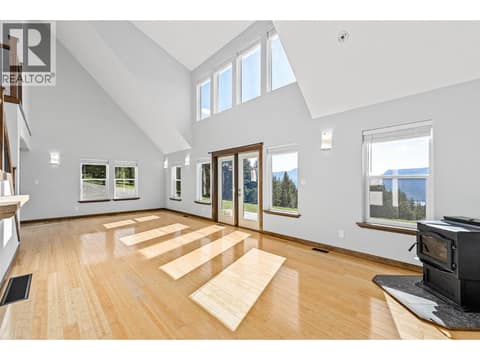 Living Room | Main Level - With tall vaulted ceilings, floor-to-ceiling windows & fireplace at 17936 Angus Road, Lake Country North West