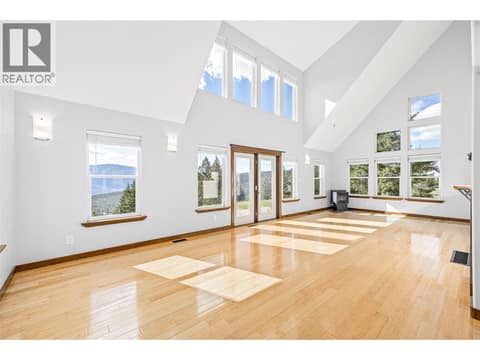 Stunning main living space with floor-to-ceiling windows, fireplace, and incredible views at 17936 Angus Road, Lake Country North West