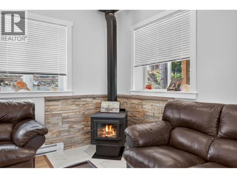 Wood fireplace in the living room of the main floor at 10818 Westshore Road, Okanagan North, Vernon